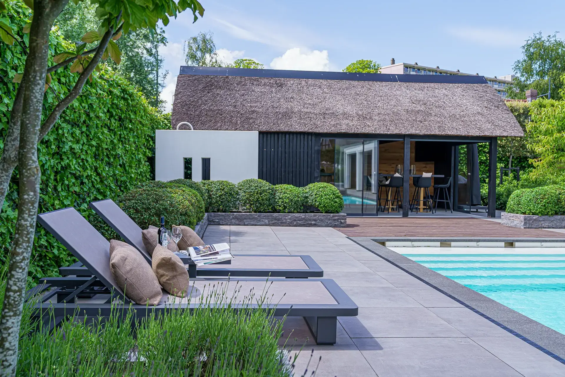 Terras met buitenverblijf en loungehoek naast het zwembad.