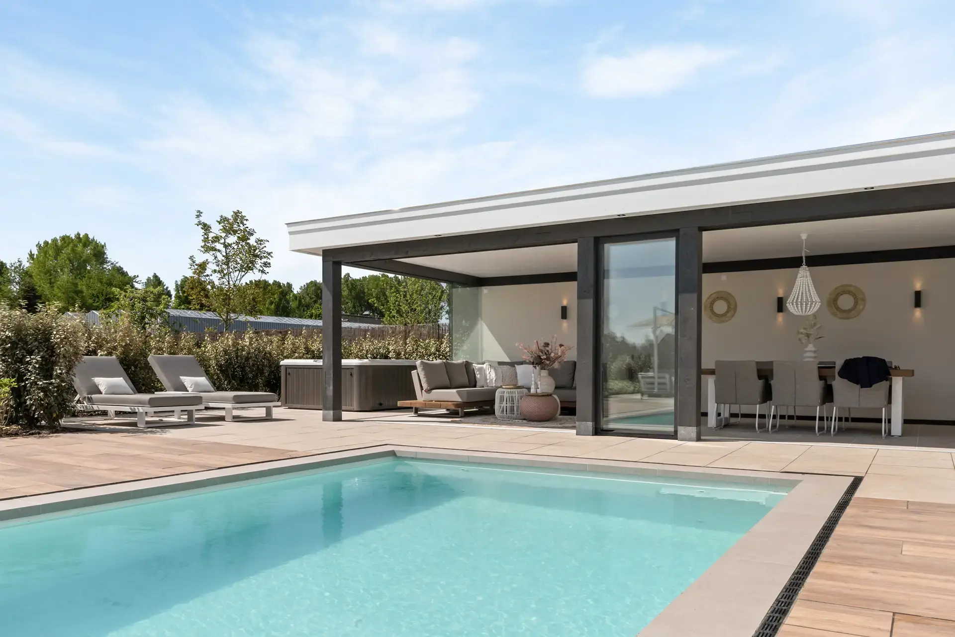 Zwembad met aangrenzend poolhouse en ruim terras eromheen.