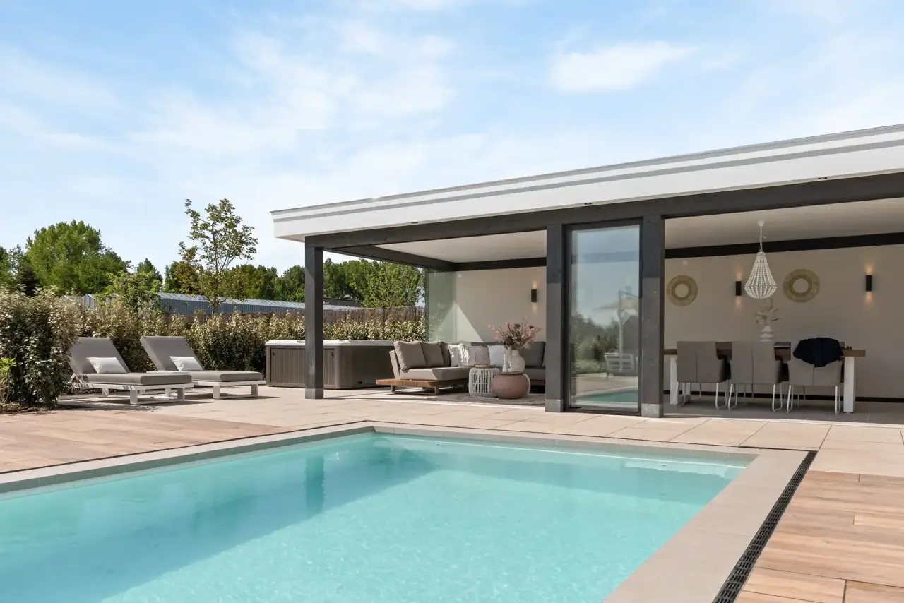 Zwembad met aangrenzend poolhouse en comfortabele ligbedden.
