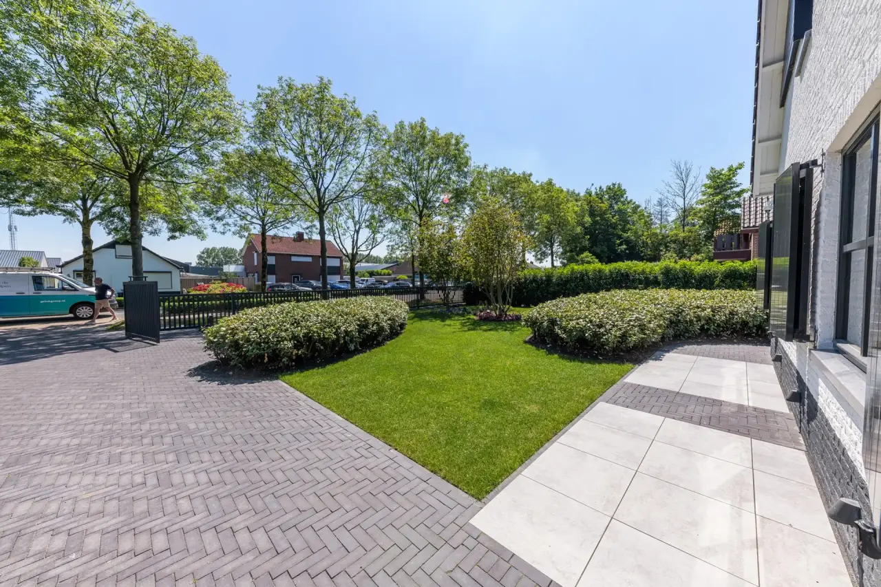 Ruime oprit met hagen en sierbestrating in tuinontwerp van Art Verde