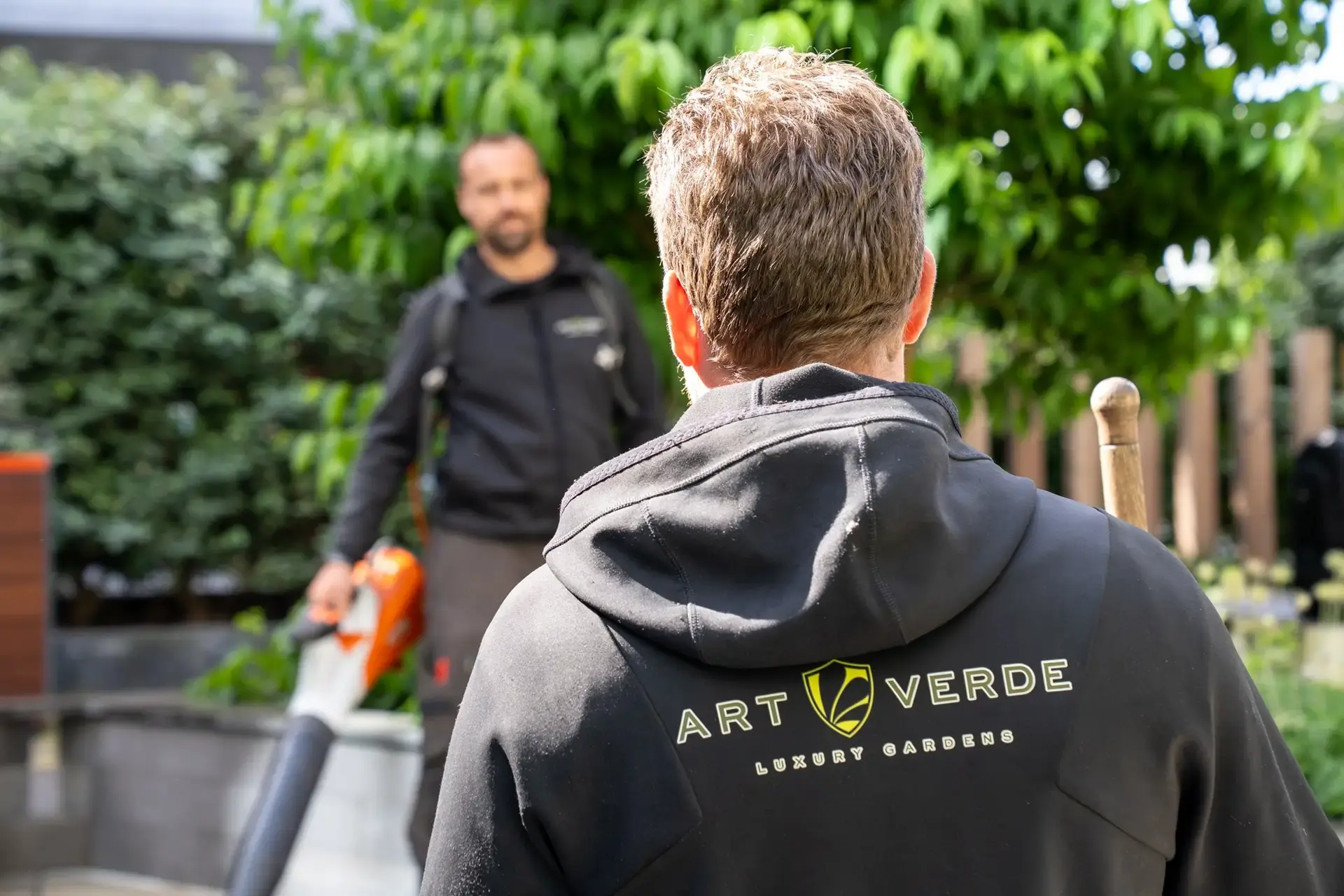 Teamleden van Art Verde Luxury Gardens aan het werk in een groene tuinomgeving