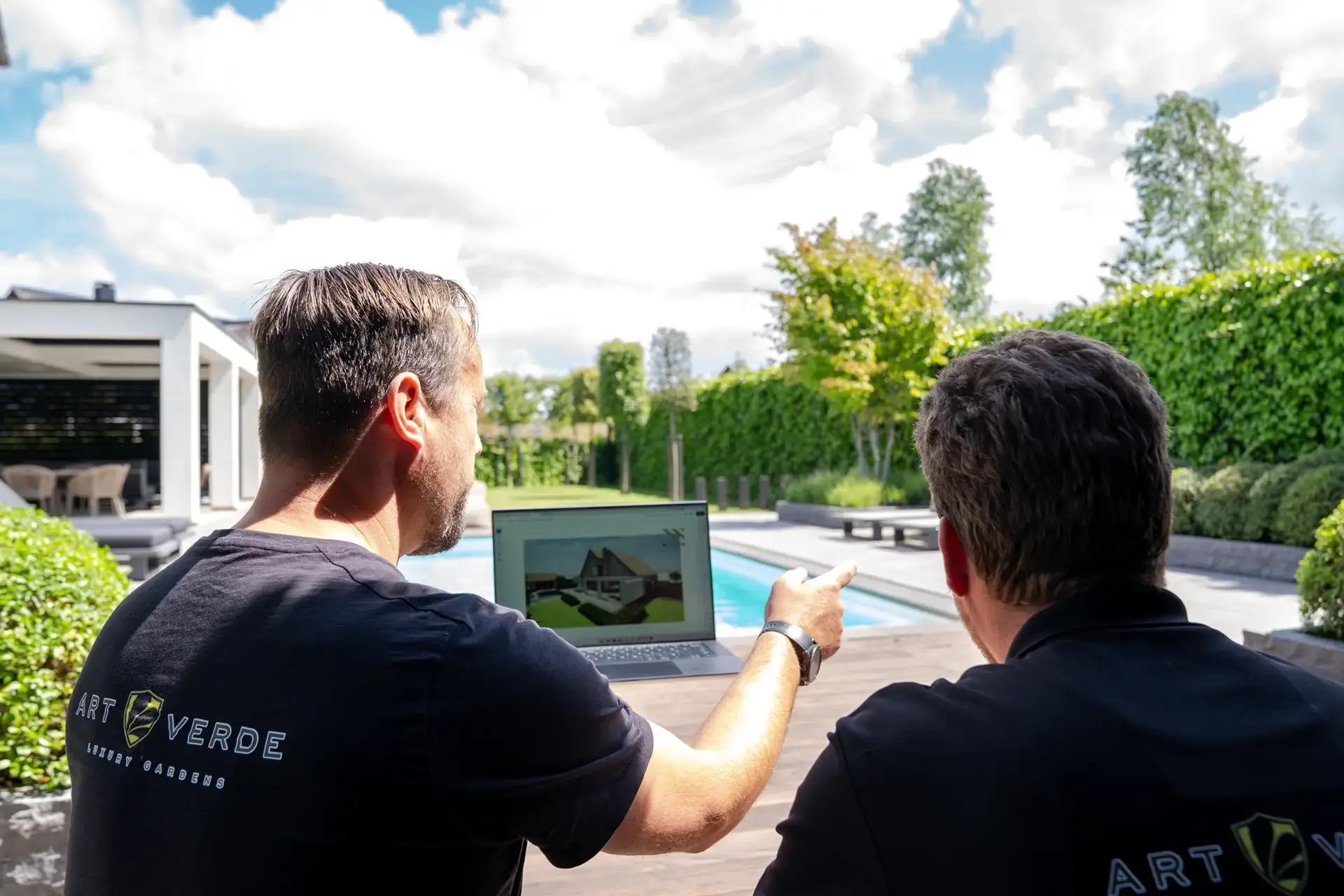 Tuinontwerpers van Art Verde overleggen bij een zwembad over het ontwerp van een exclusieve tuin