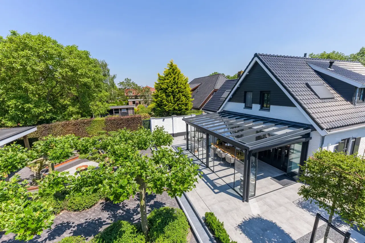Luchtfoto van tuin met veranda, borders en waterpartij ontworpen door Art Verde