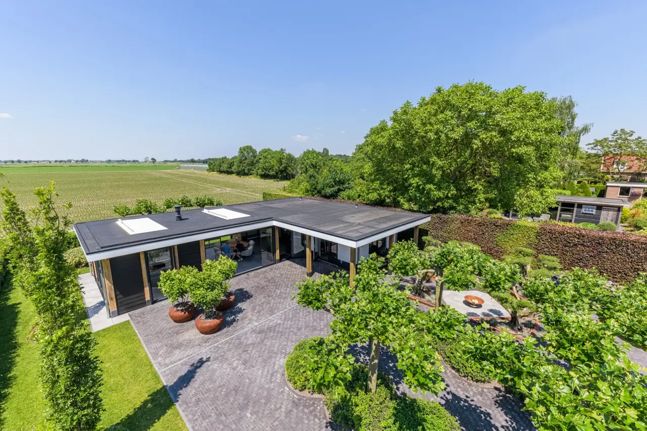 Luchtbeeld van moderne tuin met tuinkamer, veranda en groene beplanting in Bruinisse