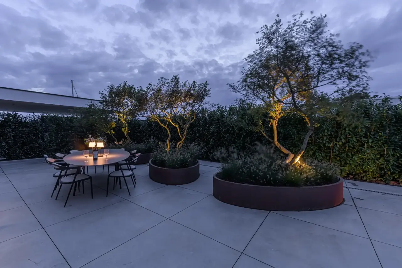 Intieme zithoek met olijfboom en sfeervol licht in luxe tuin van Art Verde